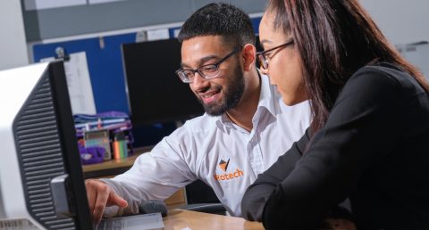  Rotech employee speaking with a customer in front of computer